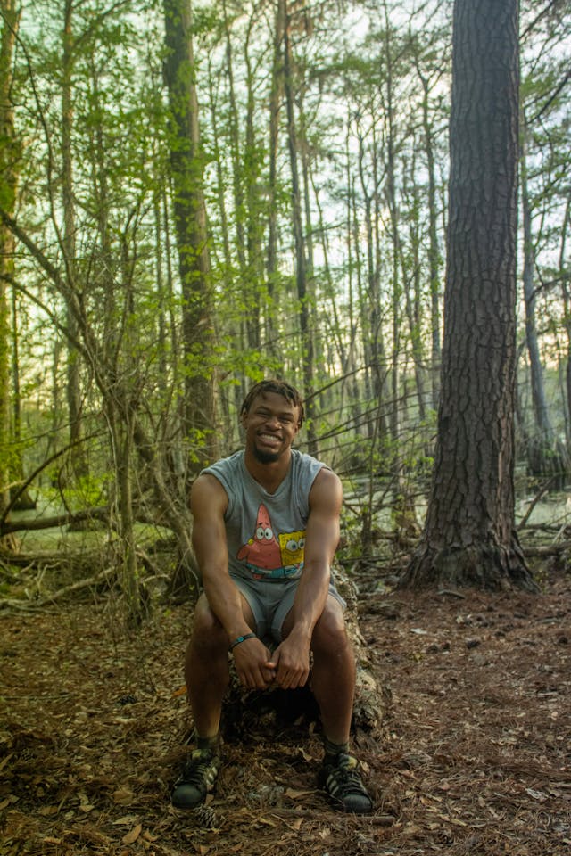 Person sitting on a log in a forest