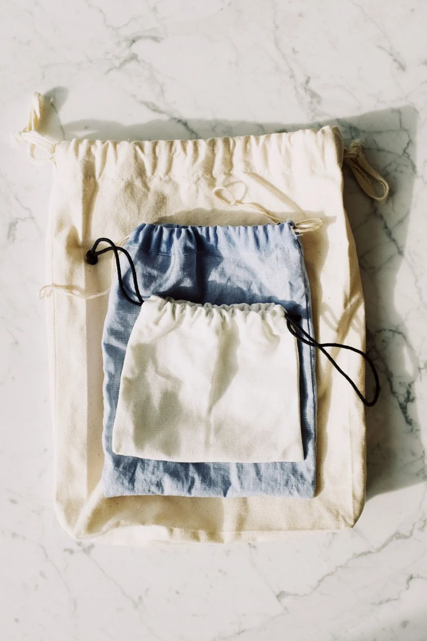 Reusable cotton drawstring pouches in natural light — ideal fabric storage bags for toys