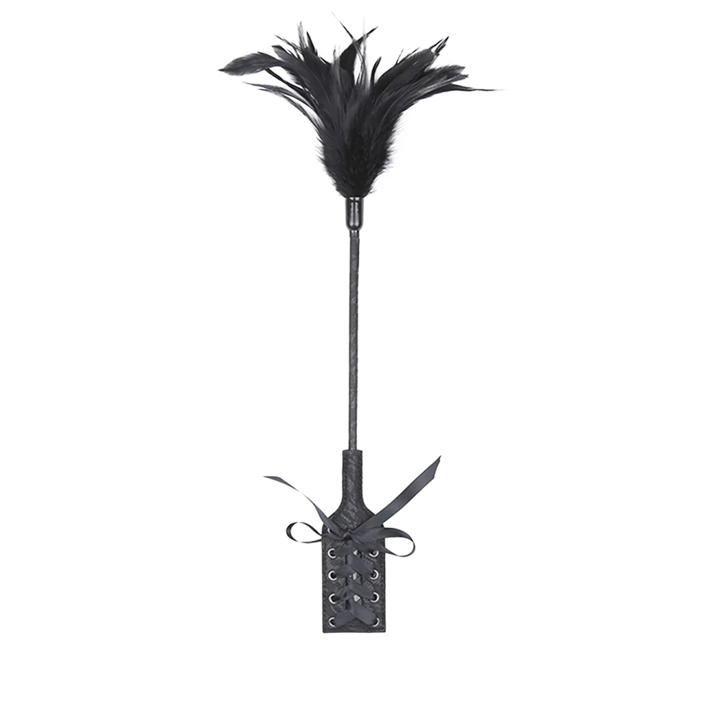 Black feather whip with an attached paddle with vintage design on a white background.
