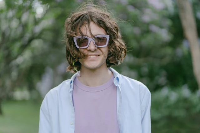 Person wearing sunglasses with a blurred natural background