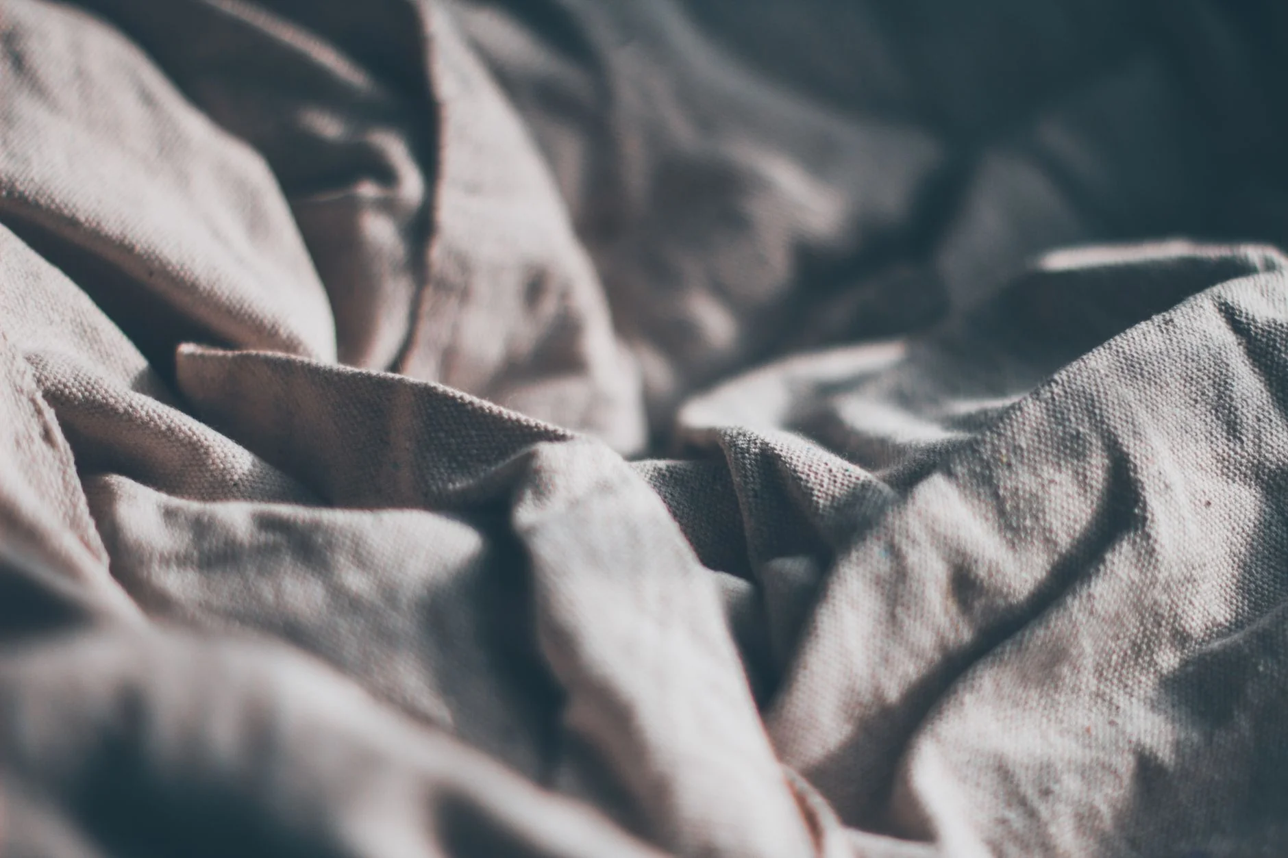 Soft linen fabric texture in natural tones, illustrating body-safe toy materials and feel