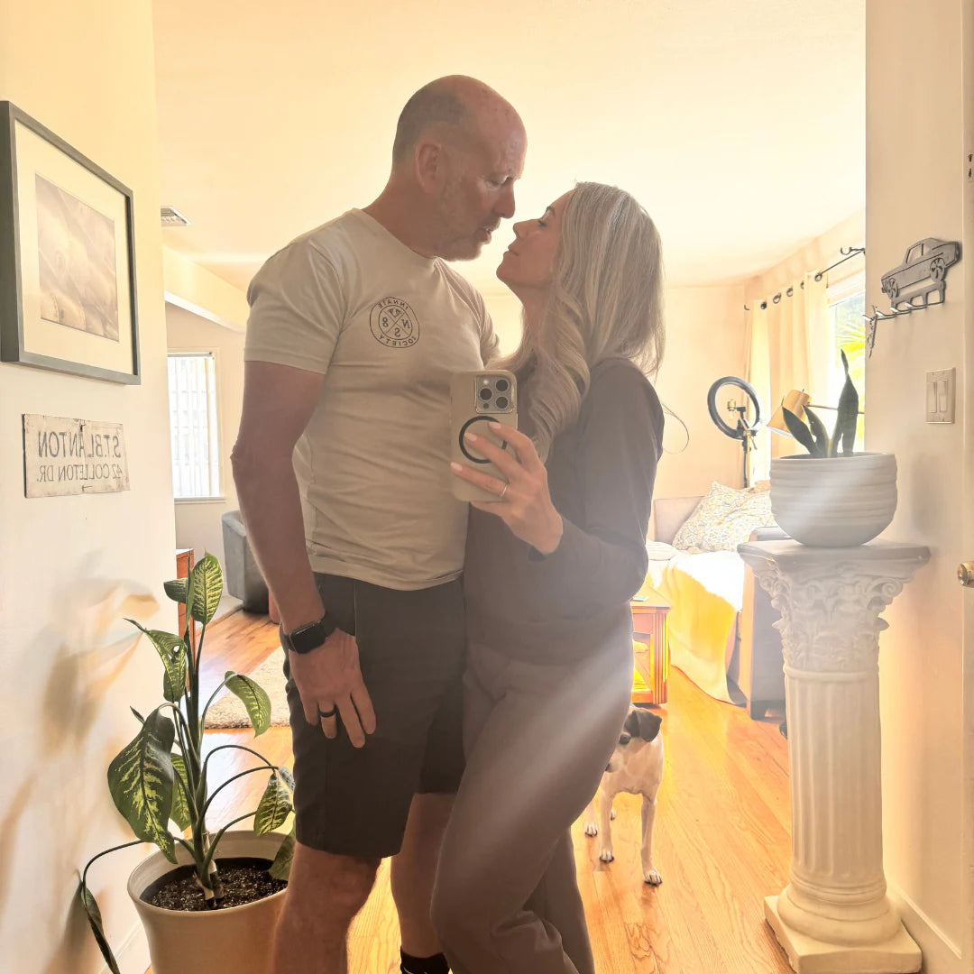 Man and woman embracing in a living room with decor elements.