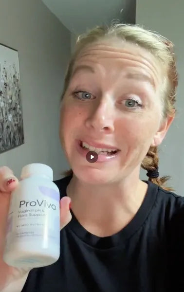 Woman holding a ProViva supplement bottle indoors