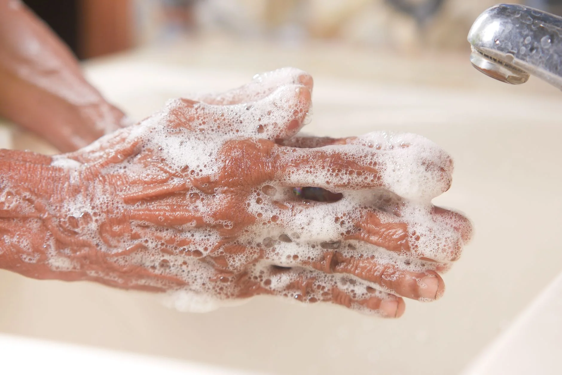 Hands with soap lather — gentle cleaning and care for sensitive skin