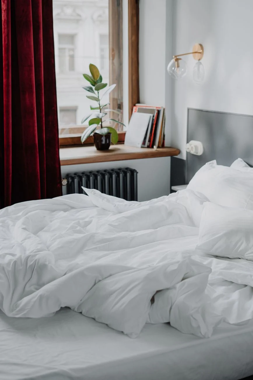 Calm bedroom with soft white linens — a guide to body-safe sex toy materials