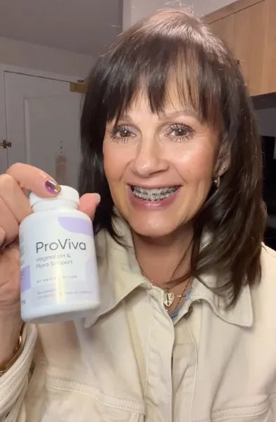 Woman holding a ProViva supplement bottle indoors