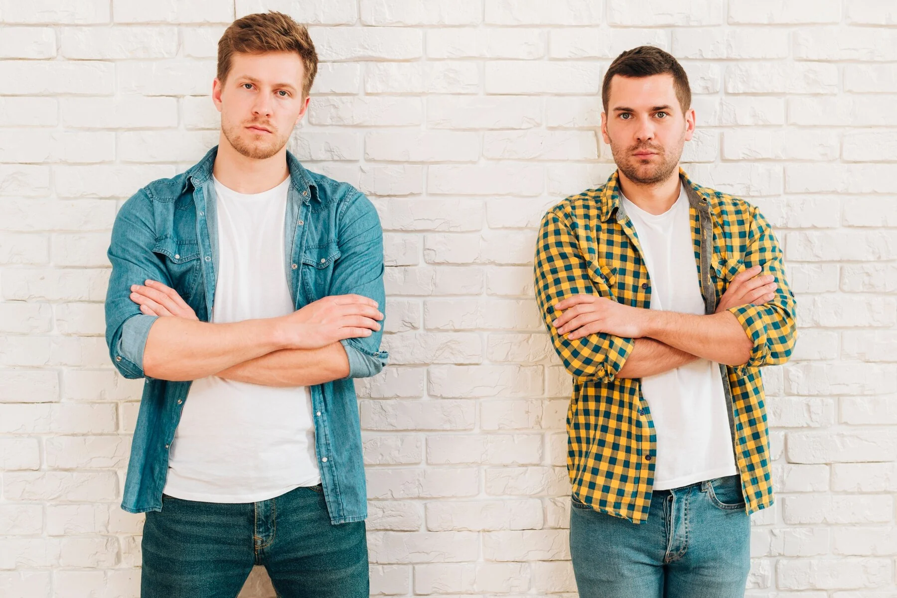 portrait two young male friends with their arms crossed looking camera 23