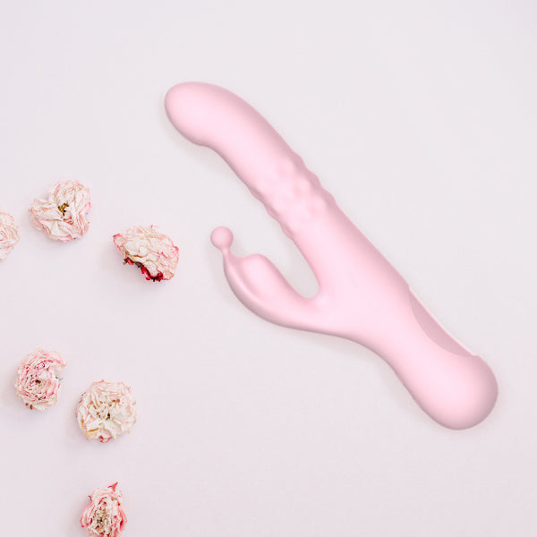 Elizabeth flat lay against a light pink backdrop with flowers