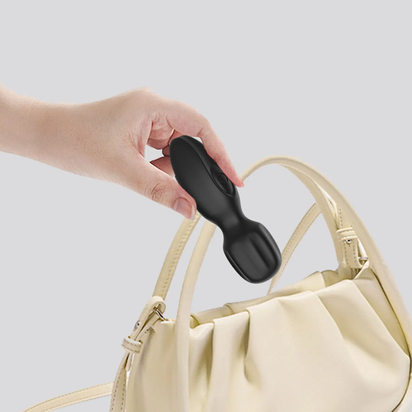 Hand holding Luna beside a handbag